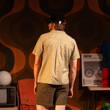 General back view of Topo Designs Daytripper Short Sleeve - Men's in "Tossed Motif Oil Green"