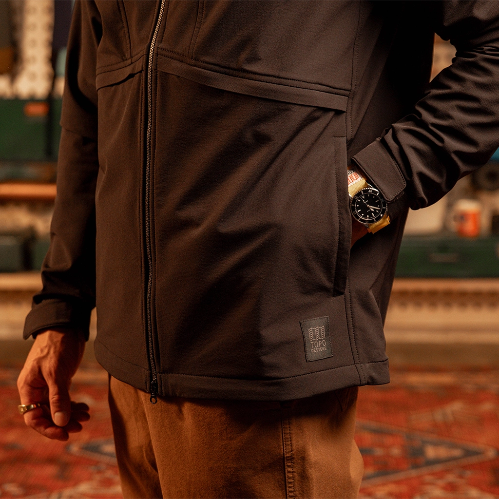 General close up view of model wearing HighPeak Jacket in 'Black' with hand in pocket. [Model is 5'11', wearing size medium]