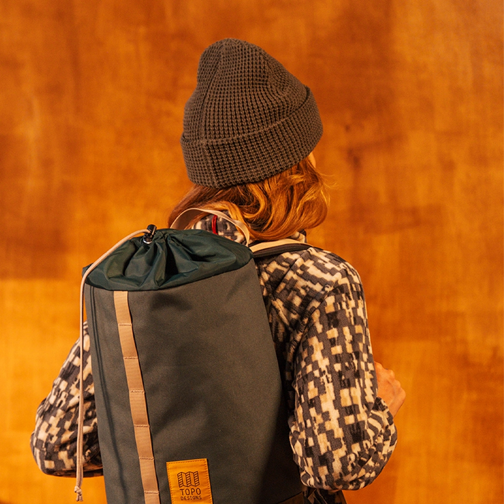 General image of person wearing a charcoal waffle knit beanie standing against a white wall.