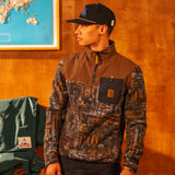 Man wearing a camouflage jacket and cap indoors with a map on the wall. [Model is 5'11", wearing size medium]
