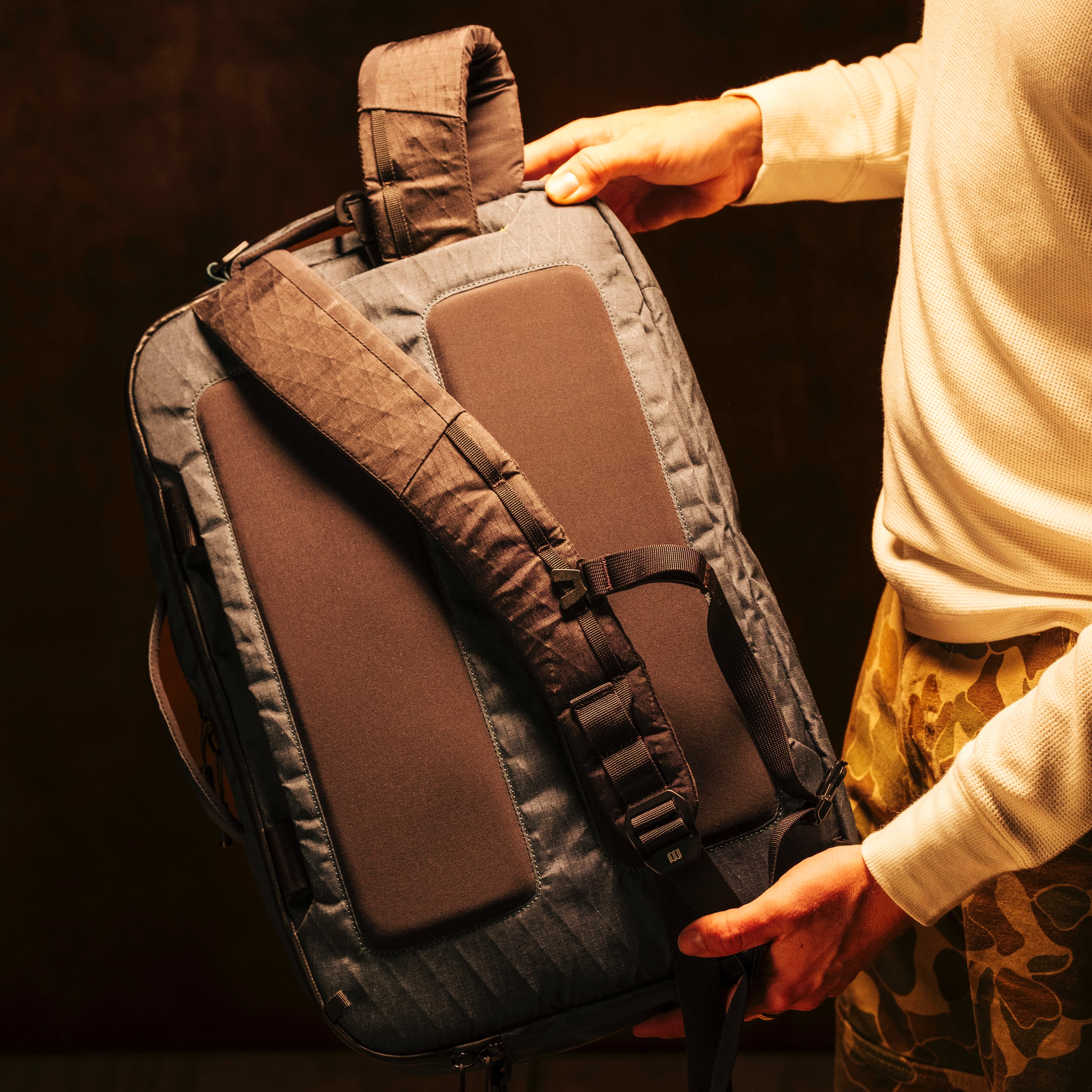 General shot of Topo Designs Global Pro 3-Way Briefcase in studio setting showing backpack straps