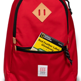 General detail view of Topo Designs Classic Teardrop Backpack in "Salsa" with the front zippered pocket opened.