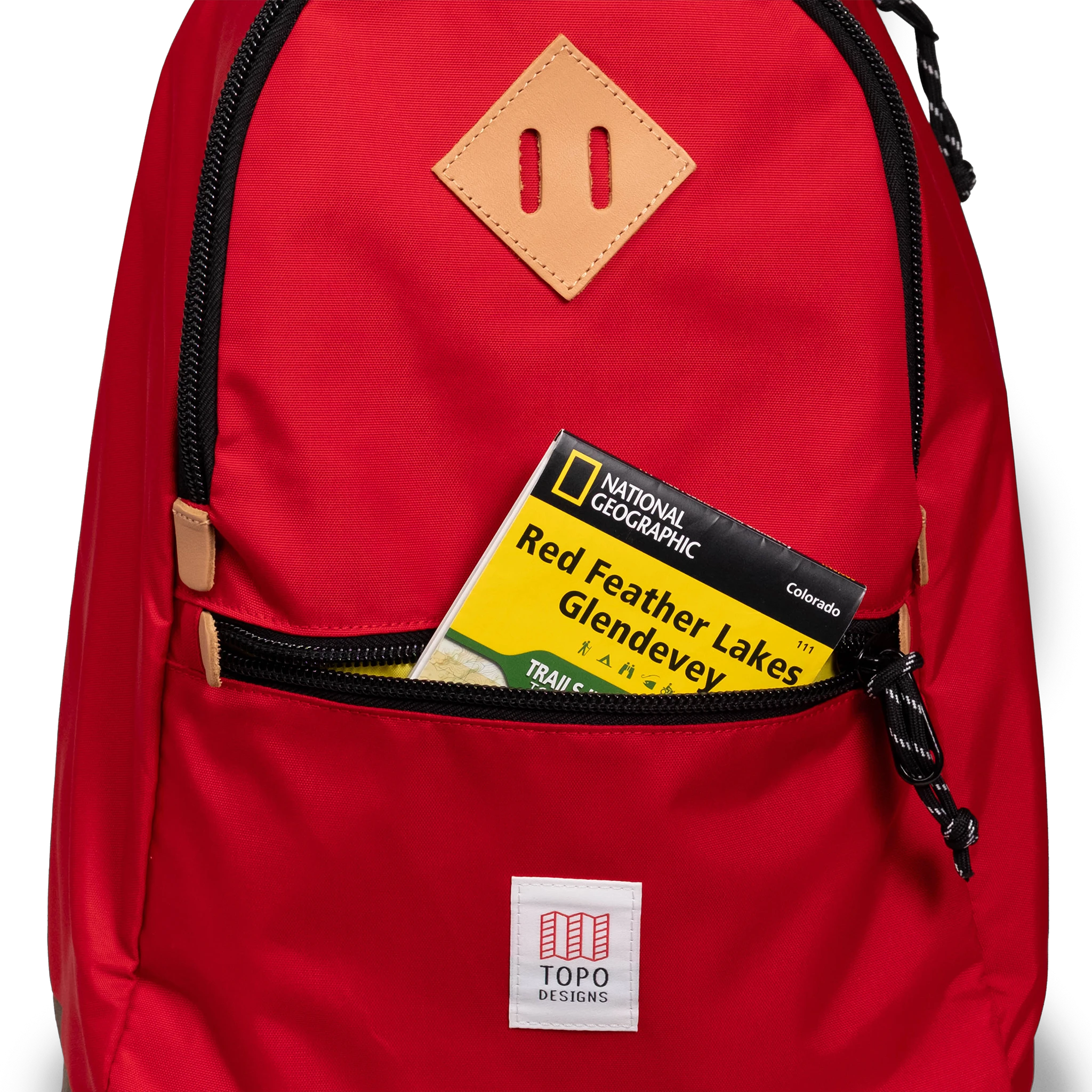 General detail view of Topo Designs Classic Teardrop Backpack in "Salsa" with the front zippered pocket opened.