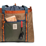 General front view of Topo Designs Mountain Utility Tote in "Olive / Dark Khaki" with notebook and keys.