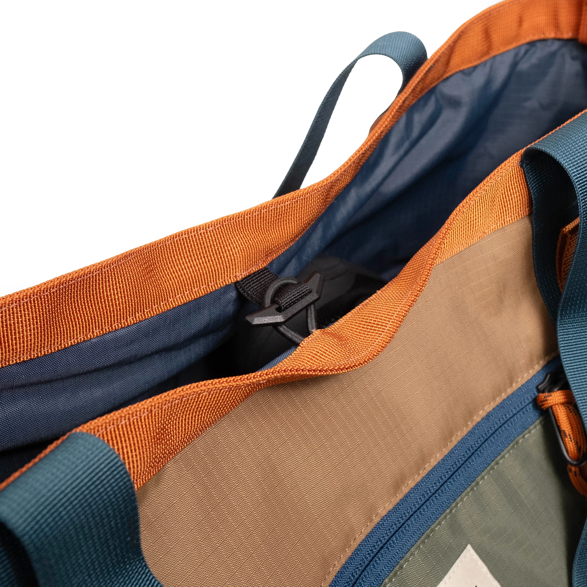 General detail shot of Topo Designs Mountain Utility Tote compartment toggle in "Olive / Dark Khaki".