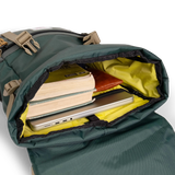 General shot Topo Designs Rover Pack Classic laptop backpack in "Forest" showing interior shot of backpack packed out with laptop, books, and glasses case.